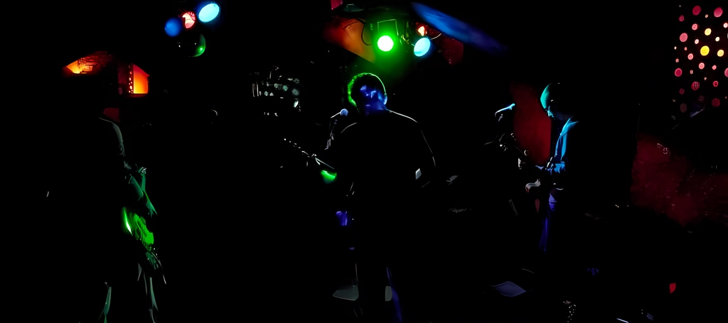 Koncert kapely RÓNIN - pohled ze zákulisí na pódium s barevným osvětlením